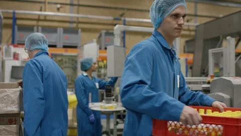 Production workers checking bottles and carrying tray in cosmetic factory Stock Footage 107955016
