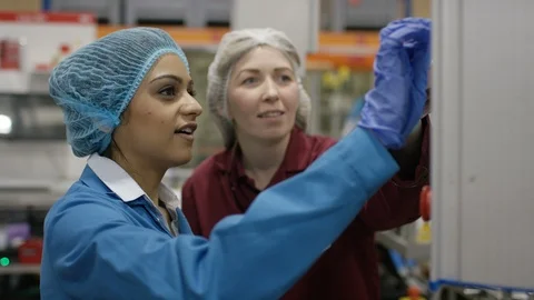 Production workers operating machine control board in cosmetic factory Video stock 107954308