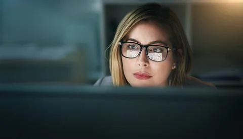 Productivity is her priority this evening. a young businesswoman working late on Stock Photos
