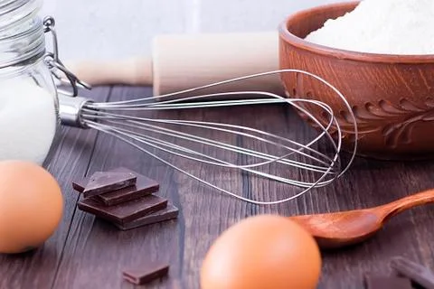 Products and objects for baking chocolate cake on dark wooden table. Concept Stock Photos