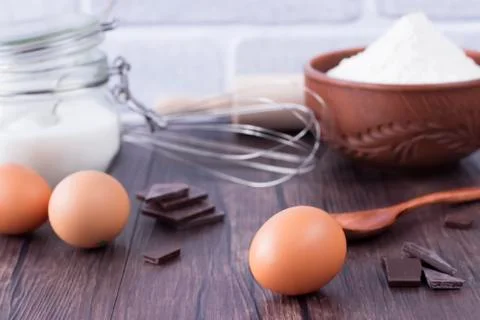Products and objects for baking chocolate cake on dark wooden table. Concept Stock Photos