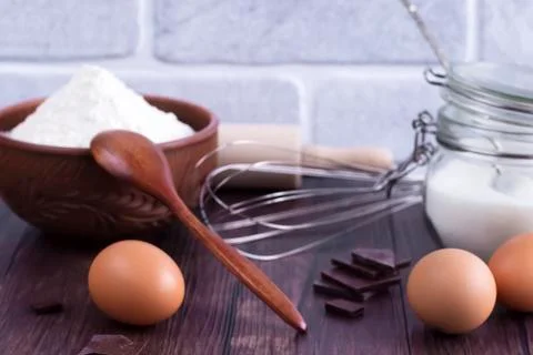Products and objects for baking chocolate cake on dark wooden table. Concept Stock Photos