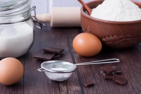 Products and objects for baking chocolate cake on dark wooden table. Concept Foto stock