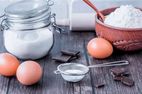 Products and objects for baking chocolate cake on dark wooden table. Concept Stock Photos