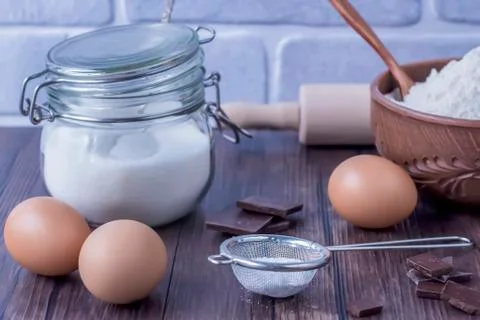 Products and objects for baking chocolate cake on dark wooden table. Concept Stock Photos
