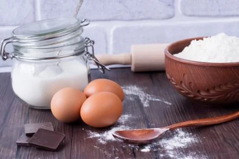 Products and objects for baking chocolate cake on dark wooden table. Concept Stock Photos