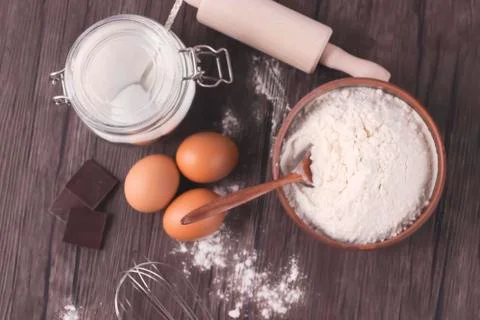 Products and objects for baking chocolate cake on dark wooden table. Concept Stock Photos