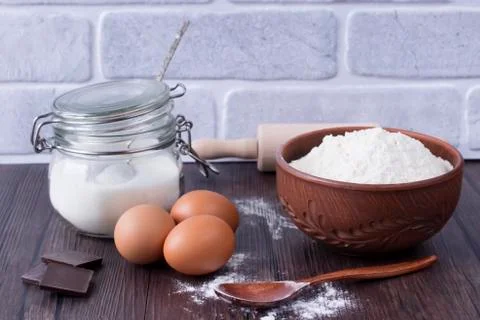 Products and objects for baking chocolate cake on dark wooden table. Concept Stock Photos