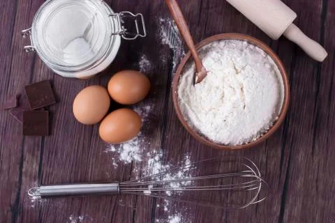 Products and objects for baking chocolate cake on dark wooden table. Concept Stock Photos