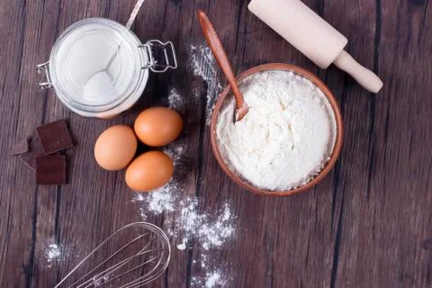Products and objects for baking chocolate cake on dark wooden table. Concept Stock Photos