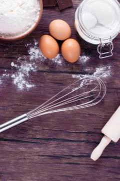 Products and objects for baking chocolate cake on dark wooden table. Concept Stock Photos