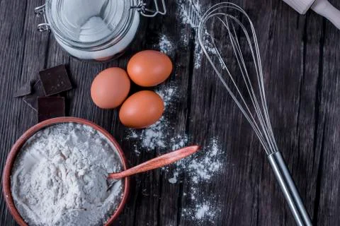 Products and objects for baking chocolate cake on dark wooden table. Concept Stock Photos