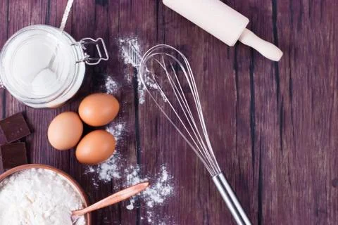 Products and objects for baking chocolate cake on dark wooden table. Concept Stock Photos