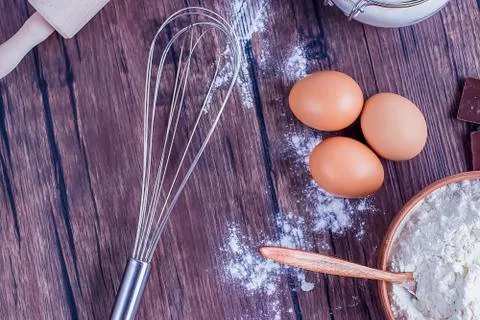 Products and objects for baking chocolate cake on dark wooden table. Concept Stock Photos