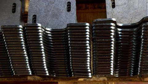 Products bent on a bending machine, close-up. Factory made metal parts. Stock Photos