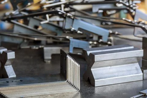 Products bent on a bending machine, close-up. Factory made metal parts. Stock Photos
