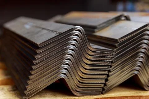 Products bent on a bending machine, close-up. Factory made metal parts. Stock Photos