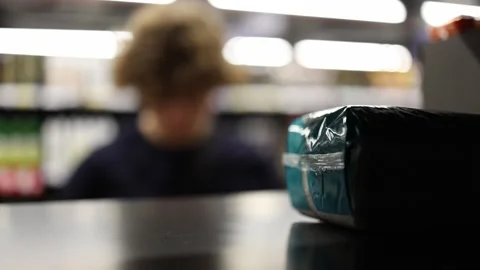 Products in sharp focus with shopper browsing groceries on blurred background Video stock 345361125