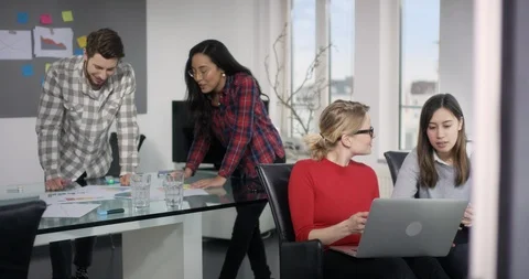 Produktive team laughing while preparing finances presentation in creative ro Stock Footage 91988647