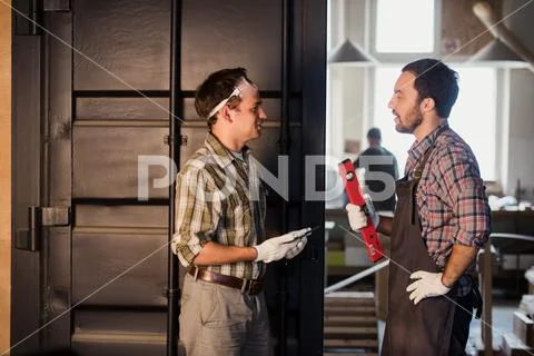 Profession, technology and people concept - two workmen with tablet pc computer Stock Photos