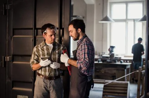 Profession, technology and people concept - two workmen with tablet pc computer Stock Photos