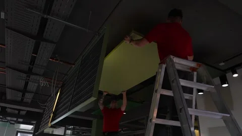 Professional acoustic ceiling panel installation. Interior team mounting large Vidéo 334265376