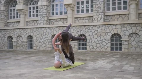 Professional acrobatic yoga. couple practising acro exercises on mat outdoors Stock Footage 150660720