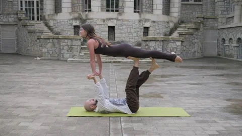 Professional acrobatic yoga. couple practising acro exercises on mat outdoors Stock Footage 150661067