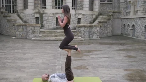 Professional acrobatic yoga. couple practising acro exercises on mat outdoors Stock Footage 150661087