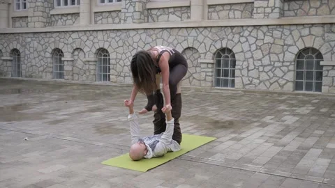 Professional acrobatic yoga. couple practising acro exercises on mat outdoors Stock Footage 150661138