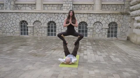 Professional acrobatic yoga. couple practising acro exercises on mat outdoors Stock Footage 150661160
