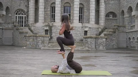 Professional acrobatic yoga. couple practising acro exercises on mat outdoors Stock-Footage 150661193