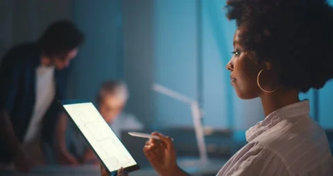 Professional afro-american architect studying blueprint on digital tablet in Stock Footage 154144211