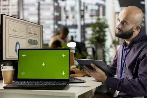 Professional analyst engages in project management next to chroma key display Stock Photos