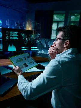 Professional analyst reviewing digital data dashboards with futuristic Stock Photos