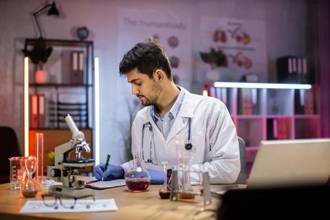 Professional arabic man microbiologist or medical worker use test tube filling Stock Photos
