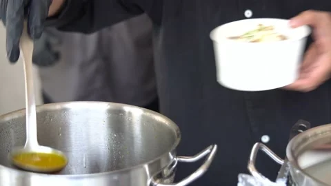 A professional Asian chef putting the broth on top of laham (lamb meat) porridge Stock Footage 211575706