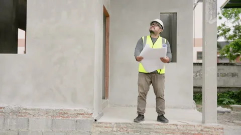 Professional Asian engineer walking in white helmet, yellow vest carry building Stock Footage 265255140