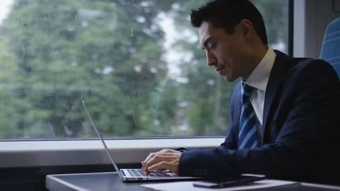Professional asian male working on his laptop on a train Stock Footage