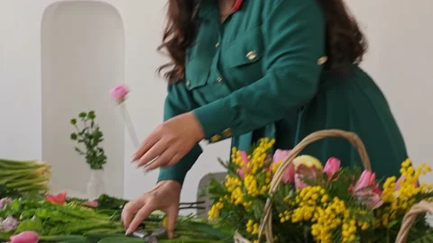 A professional assembles flower arrangement with mimosa and tulip. Vidéo 237623137