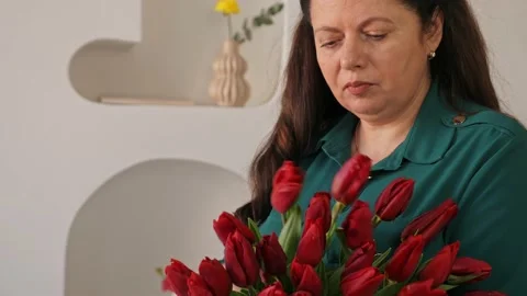 A professional assembles flower arrangement with mimosa and tulip. Stock-Footage 237623360
