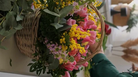 A professional assembles flower arrangement with mimosa and tulip. Stock Footage 237688000