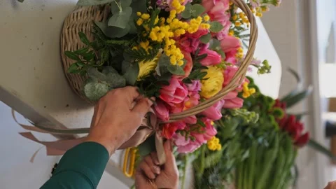 A professional assembles flower arrangement with mimosa and tulip. Stock Footage 237688071