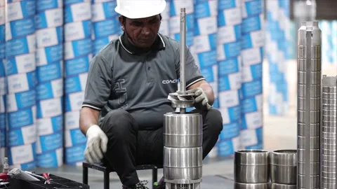 Professional assembly worker in a installing stainless steel impeller onto long Stock Footage 332728190