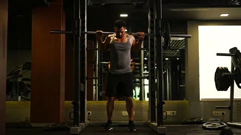Professional athlete bodybuilder working out in the indoor gym. weight liftin Stock Footage 162655788