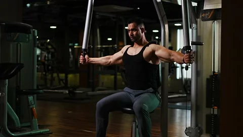 Professional athlete bodybuilder working out in the indoor gym. weight liftin Stock Footage 162656113