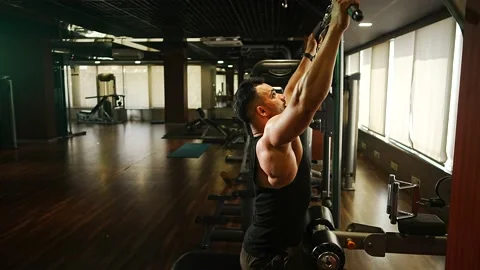 Professional athlete bodybuilder working out in the indoor gym. weight liftin Stock Footage 162656326