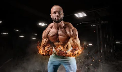 Professional athlete with fiery hands posing in the gym. Bodybuilding, fitn.. Stock Photos