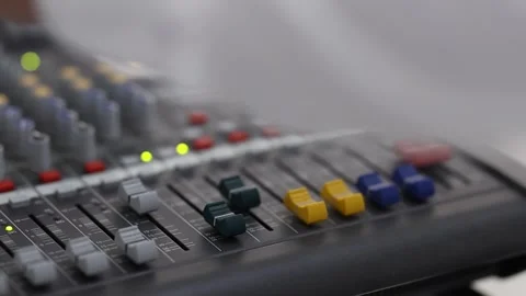 Professional audio mixing console with colored faders, glowing level indicators 库存影片 346083345