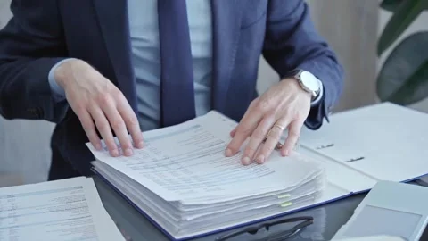Professional auditor sorting through documents at desk. Close-up of a Stock Footage 276671432
